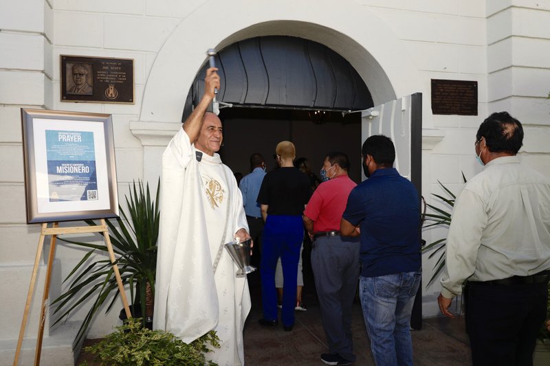 Rev. Arturo Corral-Nevarez blesses parishioners as they pass through the Holy Doors at Our Lady Queen of Angels (La Placita) Church. (David Amador)