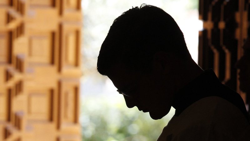 A Legionaries of Christ seminarian is silhouetted as he attends a Mass in the chapel of Regina Apostolorum University in Rome in this 2013 file photo. A network of offshore trusts and subsidiaries established by priests and businessmen close to the Legionaries of Christ moved as much as $295 million around four continents. (CNS photo/Paul Haring)