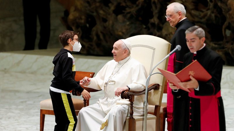 Pope Francis greets 10-year-old Paolo after the boy spontaneously walked on to the stage during the weekly general audience at the Vatican Oct. 20, 2021. (CNS photo/Remo Casilli, Reuters)