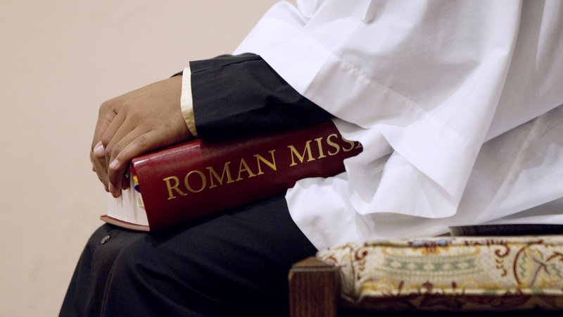 An altar server holds a copy of the Roman Missal during Mass at St. Joseph Catholic Church in Alexandria, Va., in this 2011 file photo. The Congregation for Divine Worship and the Sacraments has issued a decree formalizing changes Pope Francis made in canon law to recognize the primary responsibility of bishops, and not the congregation, for liturgical translations and cultural adaptations in the liturgy. (CNS photo/Nancy Phelan Wiechec)
