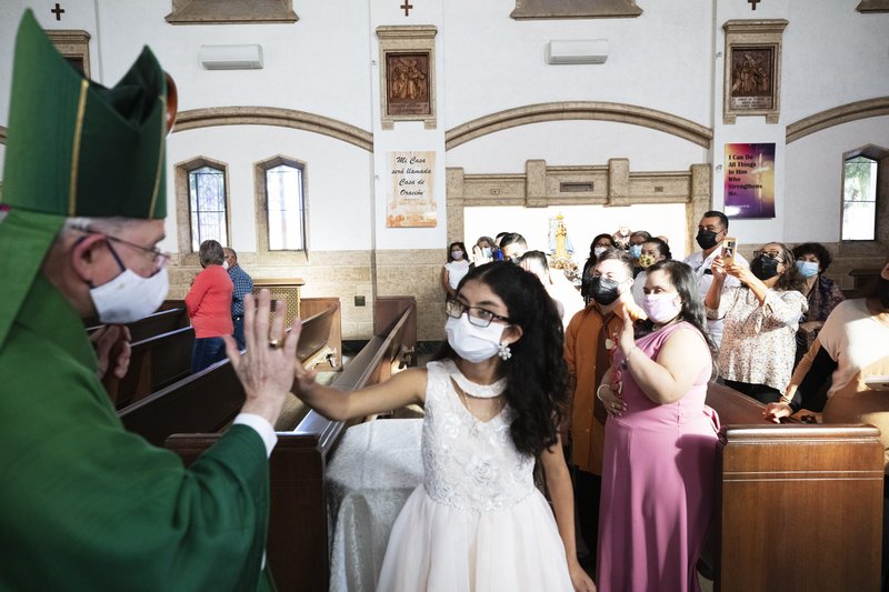 Archbishop Gomez hi-fives a young girl at the 35th annual Mass for FUERZA. (Victor Alemán)