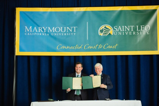 Marymount California University president Brian Marcotte and St. Leo president Jeff Senese show off signed agreements for the merger between their two schools. (Courtesy Marymount California University)