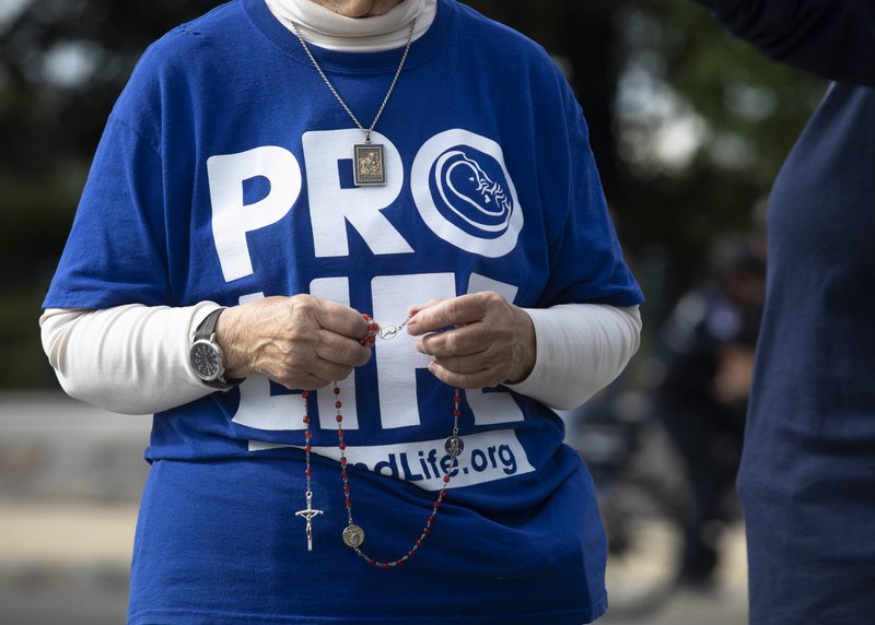 A pro-life advocate prays a rosary near the U.S. Supreme Court building in Washington, D.C., on Oct. 4, the first day of the high court's new term. (CNS photo/Tyler Orsburn)