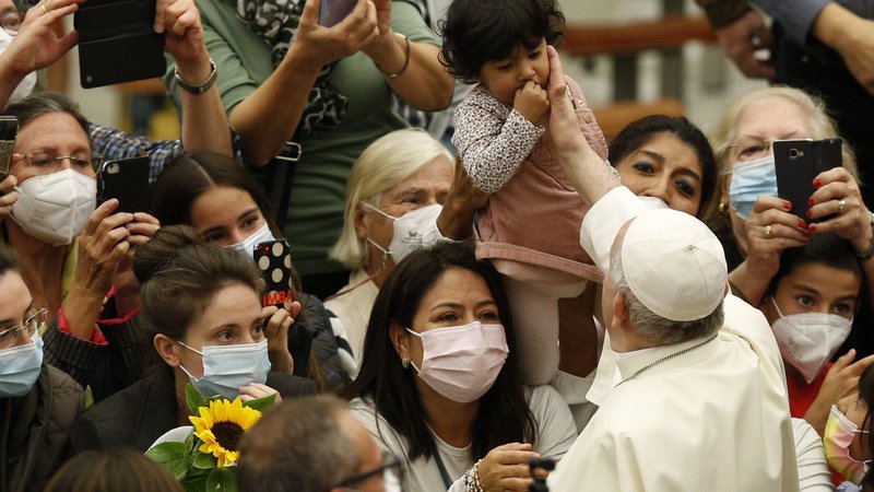 Pope Francis reaches out to a child held aloft during his general audience in the Paul VI hall at the Vatican Nov. 3, 2021. (CNS photo/Paul Haring)