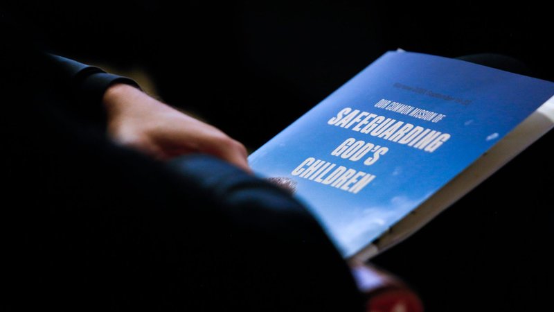 A delegate holds a program during an international conference titled, "Our Common Mission of Safeguarding God's Children," in Warsaw, Poland, Sept. 21, 2021. Pope Francis sent a message to a congress in Rome on promoting safeguarding children during the COVID-19 pandemic. (CNS photo/Polish bishops' conference)