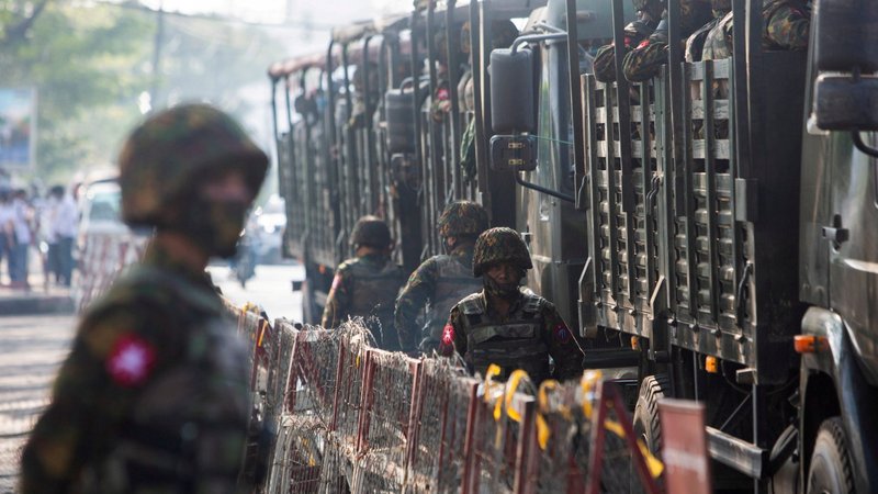 Soldiers stand next to military vehicles as people gather to protest the military coup in Yangon, Myanmar, Feb. 15, 2021. Fighting has intensified in northeastern Myanmar's Shan state as the military reinforces troops to crush local militias, and religious buildings continue to be targets. (CNS photo/Reuters)
