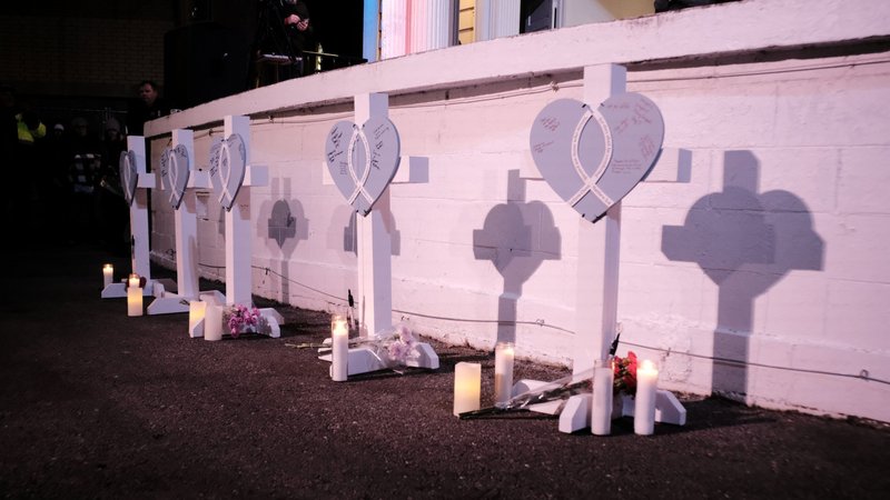 Markers for five victims are seen as Kenosha residents attend a candlelight vigil in Waukesha, Wis., Nov. 22, 2021, the day after a car plowed through a Christmas parade in the city. Pope Francis sent his condolences to the victims and families of the attack. (CNS photo/Daniel Steinle, Reuters)