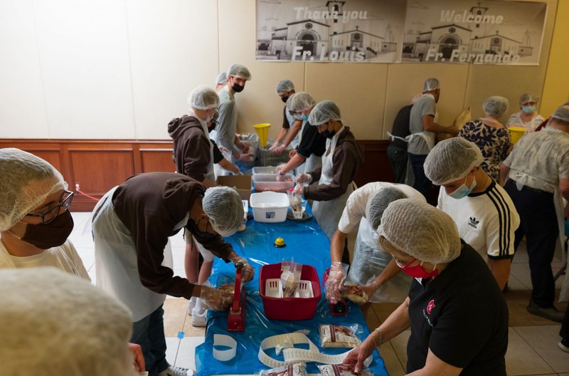 Dozens of local Catholic high school students team up with Order of Malta members at St. Peter's Italian Church to assemble meal packs for those in need. (Scott Vick)