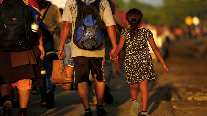 Jose Francisco from Honduras leads his 8-year-old daughter, Zuabelin, by the hand Nov. 22, 2021, as they took part in a caravan near Villa Mapastepec, Mexico, and headed to the U.S. border. (Jose Luis Gonzalez/Reuters via CNS)
