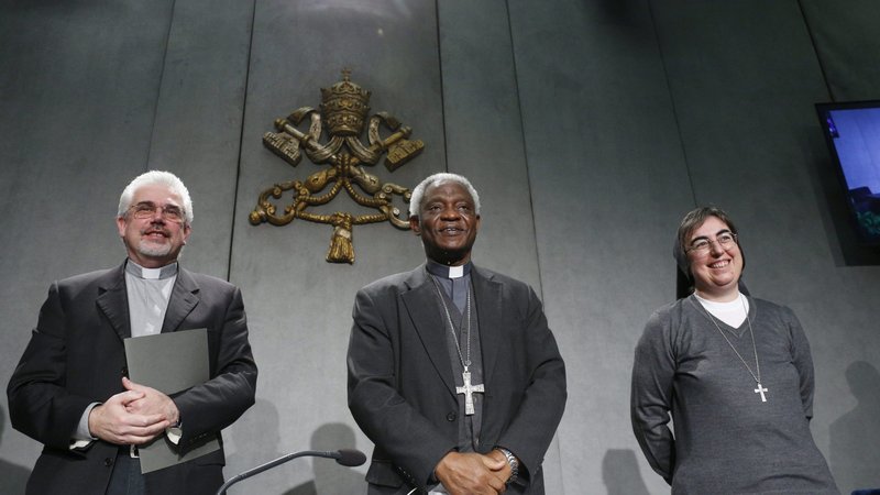 Officials at the Dicastery for Promoting Integral Human Development pose for a photo at the conclusion of a news conference at the Vatican Dec. 21, 2021, for the release of Pope Francis' message for the Jan. 1, 2022 World Day of Peace. Pictured are Scalabrian Father Fabio Baggio, undersecretary at the section for migrants and refugees; Cardinal Peter Turkson, prefect of the dicastery; and Salesian Sister Alessandra Smerilli, interim secretary. (CNS photo/Paul Haring)