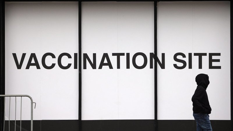A person walks past a vaccination site in New York City Dec. 18, 2021. The federal Centers for Disease Control and Prevention reported Dec. 20 that the omicron variant is now the dominant version of the coronavirus in the United States. (CNS photo/Andrew Kelly, Reuters)