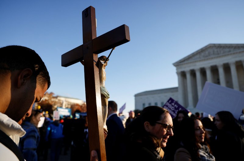 A pro-life activist holding a crucifix joins a protest outside the U.S. Supreme Court building in Washington Dec. 1, 2021, ahead of the court hearing oral arguments in the case Dobbs v. Jackson Women's Health Organization, an appeal from Mississippi to keep its ban on abortions after 15 weeks of pregnancy. (CNS/Jonathan Ernst, Reuters)