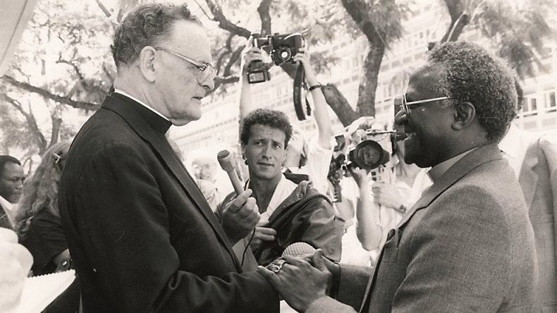 Anglican Archbishop Desmond Tutu of Cape Town shows solidarity with Catholic Archbishop Denis Hurley of Durban in a 1985 photo. Archbishop Hurley was charged with revealing atrocities committed by the apartheid regime in what is now Namibia, but the charges were dropped before the trial could begin. (CNS photo/Courtesy of the Denis Hurley Centre, Durban, South Africa)