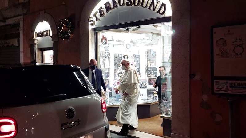 Pope Francis holds a record under his arm as he leaves the Stereo Sound record shop in Rome Jan. 11, 2022. The pope made a surprise visit to the music store he used to go to as a cardinal, receiving a record of classical music as a gift from the thrilled shop owner. (CNS photo/Javier Martinez-Brocal, Rome Reports)