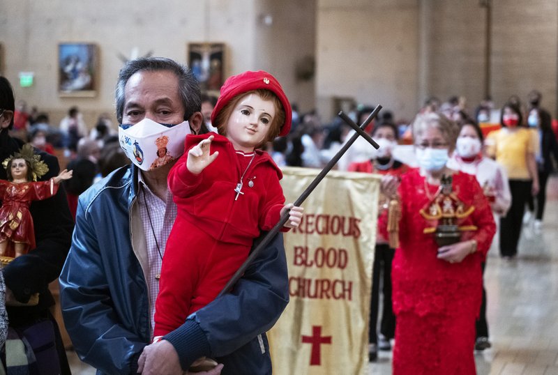 A man carries a Santo Niño statue down the aisle at the Cathedral of Our Lady of the Angels. Faithful were encouraged to bring their statues for a blessing. (Victor Alemán)