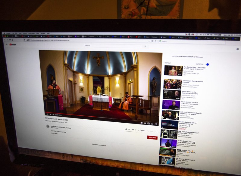 A Maryland Catholic watches from a computer screen a March 22, 2020, livestream Mass, celebrated at St. Rose of Lima Church in Gaithersburg, Maryland. (CNS photo/Chaz Muth)