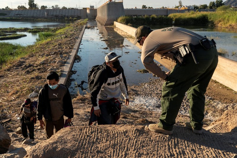 Migrants from Peru and Guatemala turn themselves in to a U.S. Border Patrol agent in Yuma, Ariz., Jan. 21, 2022. (CNS photo/Go Nakamura, Reuters)