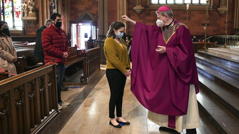 Bishop Edward B. Scharfenberger of Albany, N.Y., sprinkles ashes on parishioners during Mass at the Cathedral of the Immaculate Conception Feb. 17, 2021, amid the coronavirus pandemic. Lent 2022 begins March 2, which is Ash Wednesday. (CNS photo/Cindy Schultz, The Evangelist)