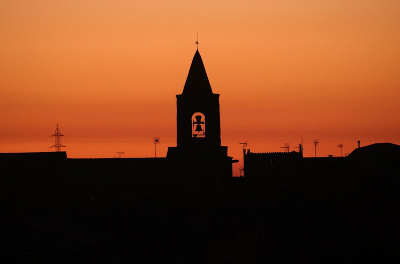 The bell tower of a church is seen during sunset in the village of Montmaneu, Spain, Jan. 28, 2022. The Spanish bishops' conference, which initially left it to individual dioceses to conduct abuse investigations, announced Feb. 22 that it has hired a law firm to conduct a yearlong study of clerical sexual abuse. (CNS photo/Nacho Doce, Reuters)