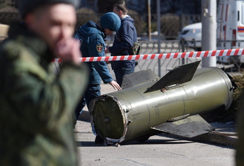 A member of the Emergencies Ministry inspects the remains of a Russian missile that landed in Donetsk, in the self-proclaimed Donetsk People's Republic, March 14. (CNS photo/Reuters)