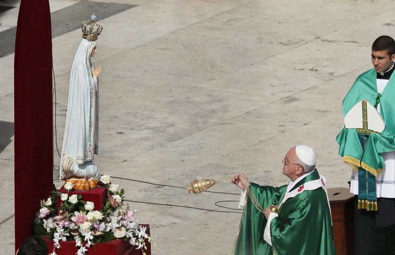 Pope Francis uses incense as he venerates the original statue of Our Lady of Fatima during a Mass at which he consecrated the world to Mary, in St. Peter's Square at the Vatican in this Oct. 13, 2013, file photo. The pope has invited the bishops of the world to join him in "consecrating and entrusting" Russia and Ukraine to Mary March 25. (CNS photo/Paul Haring)