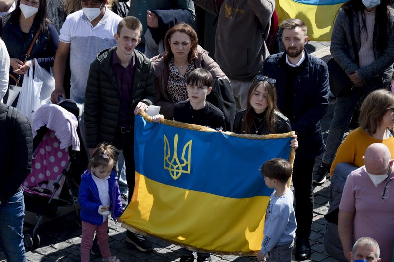 Young people hold a Ukrainian flag as Pope Francis speaks to visitors gathered in St. Peter's Square at the Vatican for the recitation of the Angelus prayer March 20, 2022. The pope condemned Russia's war on Ukraine, calling it a "senseless massacre" and "sacrilegious" attack on human life. (CNS photo/Vatican Media)
