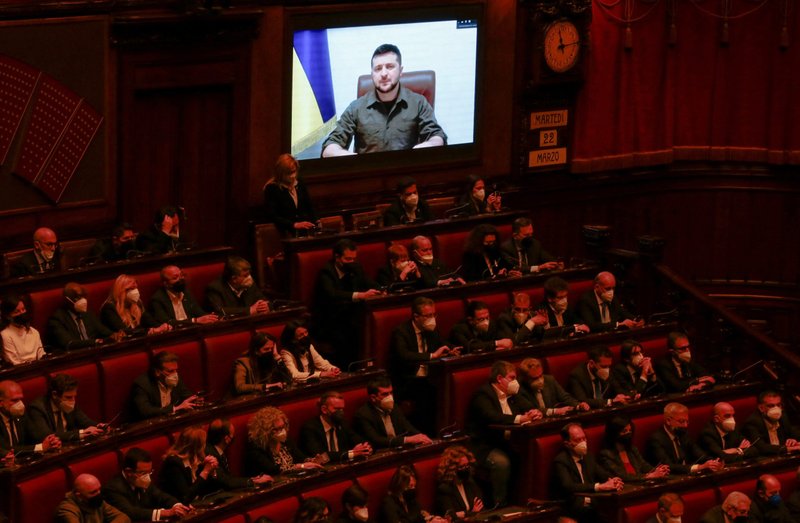 Ukrainian President Volodymyr Zelenskyy appears on screens as he receives a standing ovation at the end of his address to the Italian parliament via video link, in Rome March 22, 2022, during Russia's invasion of Ukraine. Zelenskyy spoke on the phone with Pope Francis before addressing the parliament. (CNS photo/Remo Casilli, Reuters pool)
