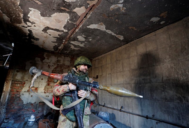 A service member of pro-Russian troops checks weapons inside a building, which according to the military was previously a fighting position of Ukrainian armed forces, during the Russian-Ukrainian war in the town of Marinka, in the self-proclaimed People's Republic of Donetsk, March 22, 2022. (CNS photo/Alexander Ermochenko, Reuters)