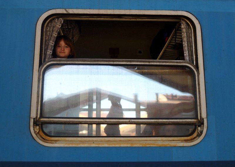 A Ukrainian girl from Kharkiv looks out a train window bound for Warsaw, Poland, March 23, 2022, with people fleeing the Russia's ongoing war in Ukraine. (CNS photo/Hannah McKay, Reuters)