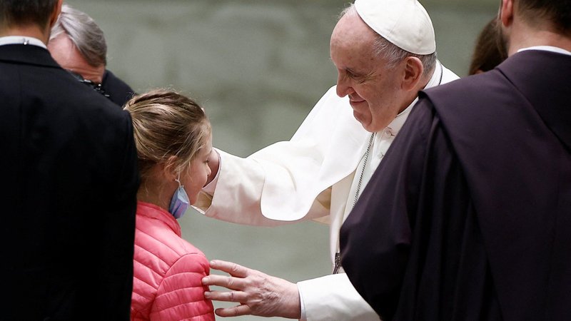 Pope Francis blesses a refugee girl who fled Russia's invasion of Ukraine, during the weekly general audience in the Paul VI hall at the Vatican March 30, 2022. (CNS photo/Guglielmo Mangiapane, Reuters)