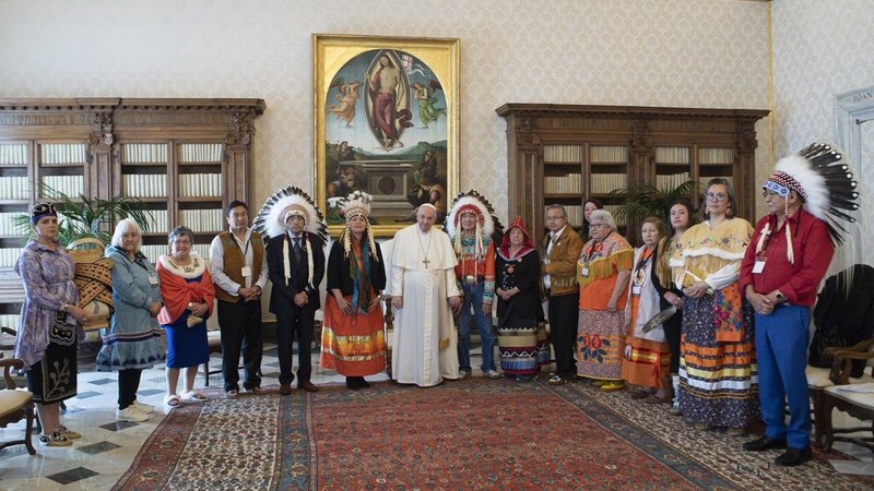 Pope Francis is pictured with Assembly of First Nations delegates during a meeting at the Vatican March 31, 2022. The delegate on the left is holding a "cradleboard," a baby carrier that the delegates asked the pope to keep overnight to remember the Indigenous children sent to residential schools. (CNS photo/Vatican Media)