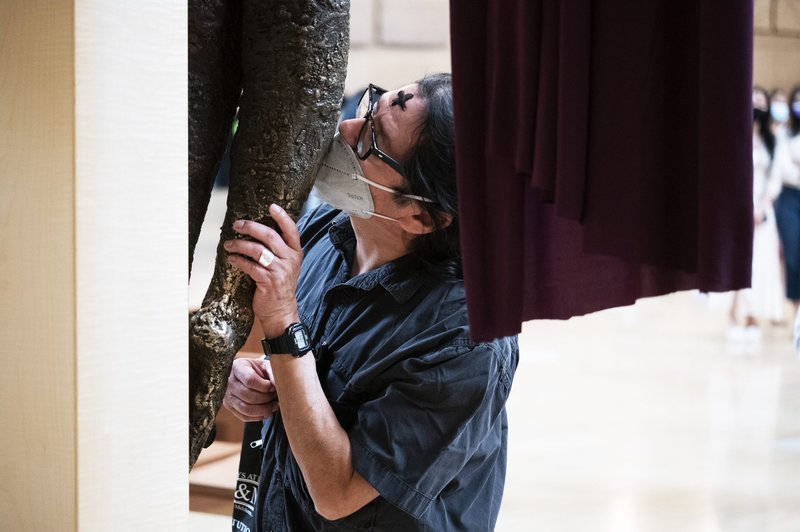 A woman kisses the feet of Jesus on the cross at Ash Wednesday Mass at the Cathedral of OurLady of the Angels. (Victor Alemán)