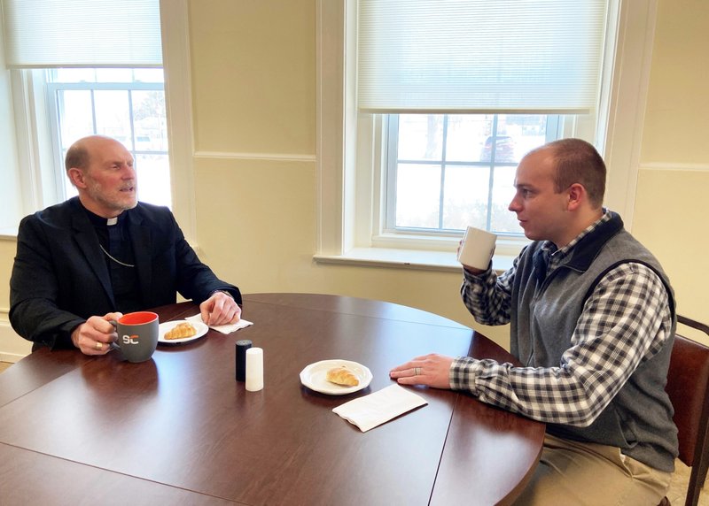 Bishop Thomas R. Zinkula of Davenport, Iowa, and Patrick Schmadeke, diocesan director of evangelization, have a conversation Jan. 28, 2022, about the "58,000 Cups of Coffee Initiative." It is "a deep and thorough listening" process involving diocesan Catholics as part of local preparations for the church's 2023 world Synod of Bishops on synodality. (CNS photo/Barb Arland-Fye, The Catholic Messenger)