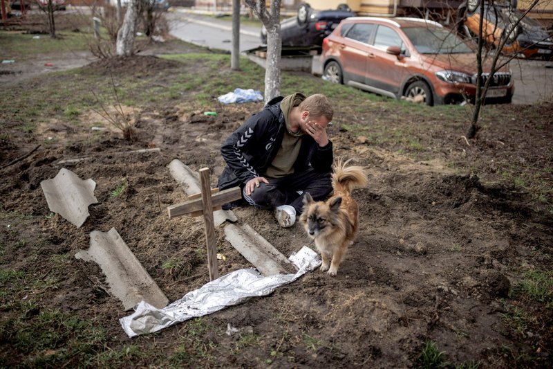 A man mourns next to the grave of his friend in Bucha, Ukraine, on April 6. (CNS/Alkis Konstantinidis, Reuters)