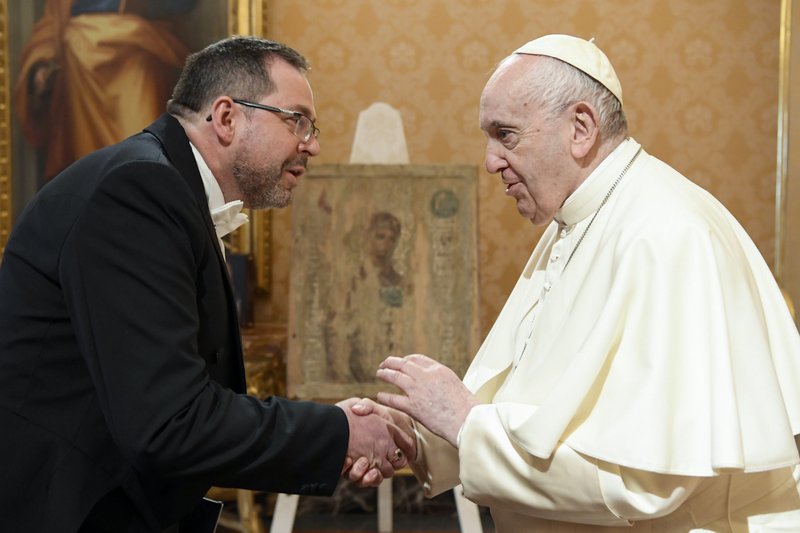 Pope Francis greets Andrii Yurash, Ukraine's ambassador to the Holy See, during a meeting for the ambassador to present his credentials to the pope at the Vatican April 7, 2022. In the background is a Ukrainian icon from the 17th or 18th century that was hidden from the Soviets by making it part of a cupboard door in a church in the town of Popeliv. (CNS photo/Vatican Media)