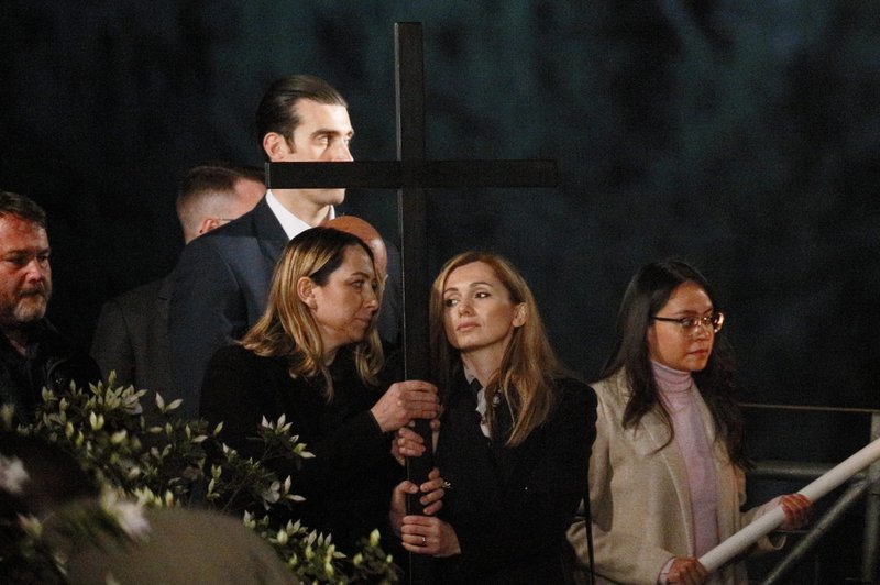 Ukrainian nurse Iryna and Russian nursing student Albina, who are friends, hold a cross at the 13th station as Pope Francis leads the Way of the Cross outside the Colosseum in Rome April 15, 2022. (CNS photo/Paul Haring)