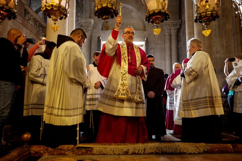Archbishop Pierbattista Pizzaballa, Latin patriarch of Jerusalem, blesses the faithful with holy water as he celebrates Easter Mass in the Church of the Holy Sepulcher in Jerusalem's Old City April 17, 2022. (CNS photo/Amir Cohen, Reuters)