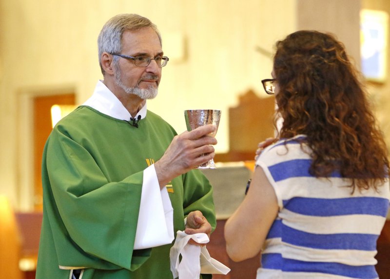 Deacon Michael Boldizar hands the chalice to a communicant during Mass July 21, 2019, at St. Anne Church in Garden City, N.Y. (CNS photo/Gregory A. Shemitz)