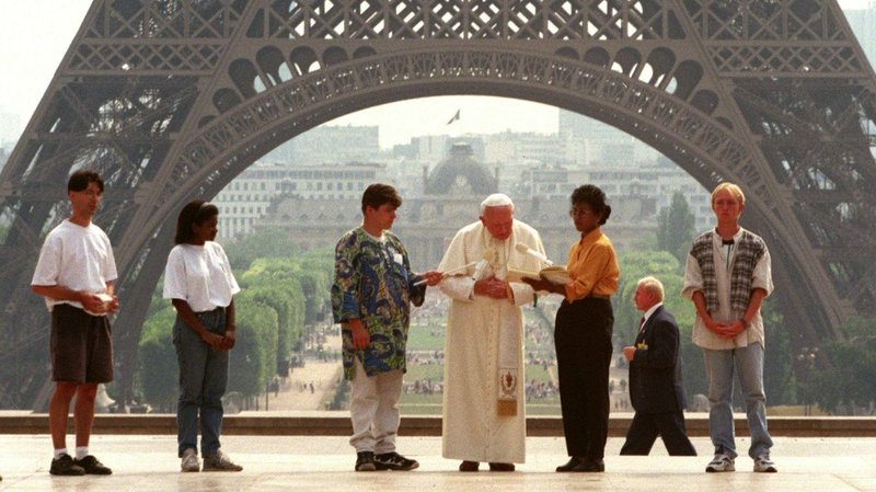 Pope John Paul II, standing near the Eiffel Tower, greets young people from around the world during the 1997 World Youth Day in Paris. (CNS photo/Paolo Cocco, Reuters)