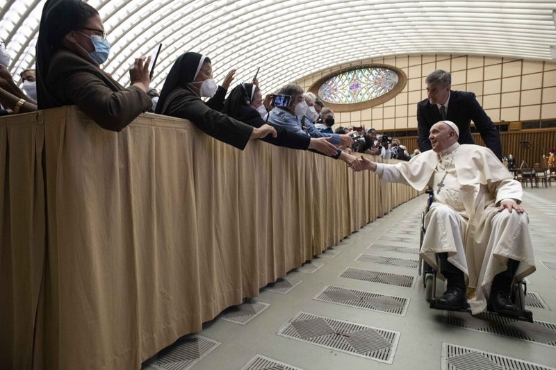 Pope Francis is pushed in a wheelchair by his aide, Sandro Mariotti, as he greets participants in the plenary assembly of the women's International Union of Superiors General (UISG) at the Vatican May 5, 2022. (CNS photo/Vatican Media)