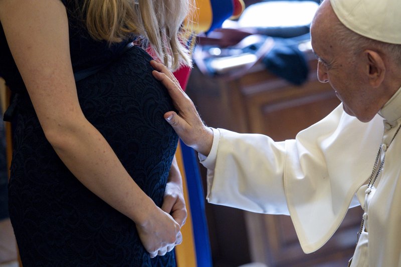 Pope Francis blesses the womb of a pregnant woman during a meeting with new members of the Swiss Guard ahead of their swearing-in ceremony at the Vatican May 6, 2022. In a message sent May 12, 2022, to participants of a conference in Rome, Pope Francis said declining birth rates in Italy and Western countries are "impoverishing everyone's future." (CNS photo/Vatican Media)