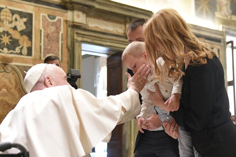 Pope Francis caresses the cheek of a boy at the Vatican May 13, 2022, while greeting participants from a conference in Rome discussing the family and moral theology. (CNS photo/Vatican Media)