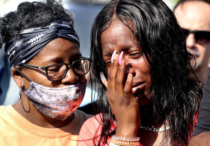 Julie Harwell, who was in the Buffalo, N.Y., TOPS supermarket when a gunman opened fire May 14, 2022, is consoled during a prayer vigil the next day. (CNS photo/Seth Harrison, USA Today Network via Reuters)