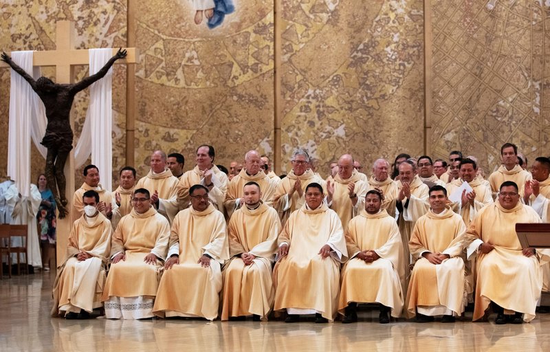 From left: Newly ordained priests Daniel Vega, Daniel Lopez, Justin Ordoveza, Kamil Ziolkowski, Ramon Reyes, Juan Gutierrez, Juan Martinez, and Guillermo “Memo” Alonso get a standing ovation at the Ordination Mass on June 4, 2022. (Victor Alemán)