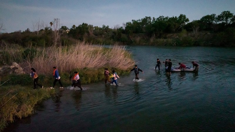 Migrants from Central and South America exit their raft onto an island in the middle of Rio Grande near Roma, Texas, June 11, 2022. (CNS photo/Adrees Latif, Reuters)