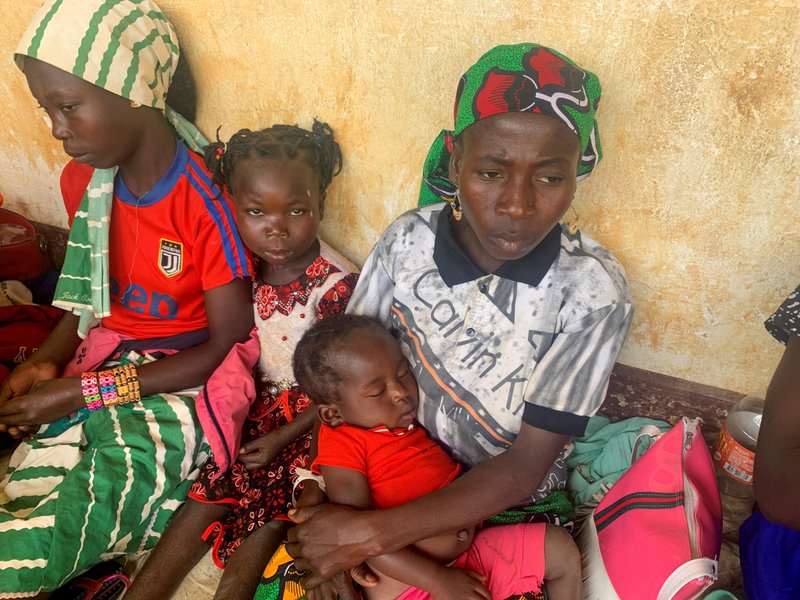 A woman who fled a violent rebellion in the Central African Republic sits with her family as they wait for their identification process in the border town of Garoua Boulai, Cameroon, Jan. 7, 2021. Bishops in the Central African Republic said the country is feeling "convulsions from the Ukraine crisis" with depleting food and fuel supplies paralyzing "the socio-economic life of the nation" and hospitals running out of equipment. (CNS photo/Joel Kouam, Reuters)