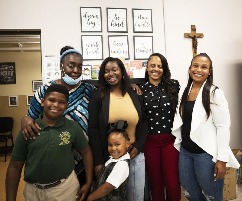 The St. Eugene "village" has long included teacher Stephanie Thomas (upper left), who has taught all the Johnson/Cotton children and Principal Celynda Wilder Kingsby (second from right) who recently hired Kamaryn Johnson to teach transitional kindergarten next school year. (Victor Alemán)