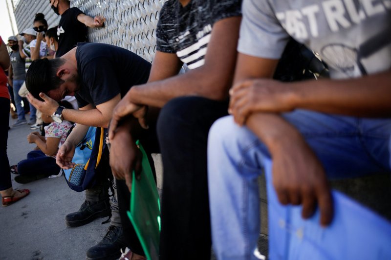 Migrants are seen outside the National Migration Institute in Ciudad Juarez, Mexico, July 8, 2020, where they had to renew their permission to stay in Mexico while awaiting an immigration hearing in the United States. (CNS photo/Jose Luis Gonzalez, Reuters)