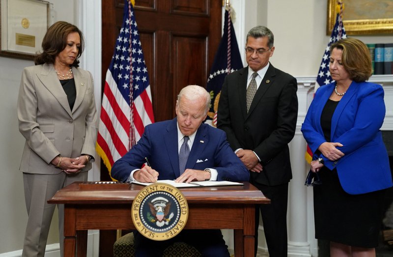 President Joe Biden signs an executive order at the White House in Washington July 8, 2022, that he said would help safeguard women's access to abortion and contraceptives. He stated the order was a necessary response to the Supreme Court's June 24 decision overturning the court's 1973 Roe v. Wade decision that legalized abortion nationwide. The high court's ruling sends the abortion issue back to the states. Pictured with Biden are Vice President Kamala Harris, left, Health and Human Services Secretary Xavier Becerra and . Deputy Attorney General Lisa Monaco. (CNS photo/Kevin Lamarque, Reuters)