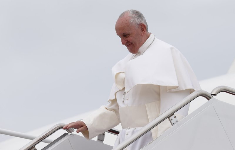 Pope Francis walks from the papal plane as he arrives at an airfield during a 2015 foreign trip. Pope Francis will be featured in a new documentary premiering at this year's Venice Film Festival. Titled, "Traveling," the film covers the pope's near decade of travel. (CNS photo/Paul Haring)